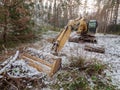 Road construction equipment in forest, yellow caterpillar excavator