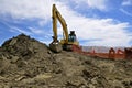 Road construction site with excavating machine