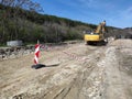 road construction site with excavator and safety barriers