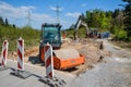 Road construction using compactor, hydraulic excavator