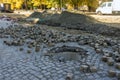 A road construction work on preparation for installation of sewer hatches the laying stones on road Royalty Free Stock Photo