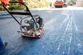 Road construction with worker paving the fresh bitumen or asphalt