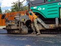 Road construction worker shoveling the hot asphalt.