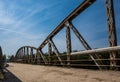 Road with cracked asphalt on the bridge over the river on warm s