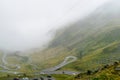 The road that crosses the Fagaras mountains seen from above among the fog, Transfagarasan, Romania Royalty Free Stock Photo