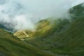 The road that crosses the Fagaras mountains seen from above among the fog, Transfagarasan, Romania Royalty Free Stock Photo