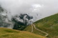 The road that crosses the Fagaras mountains seen from above among the fog, Transfagarasan, Romania Royalty Free Stock Photo