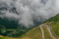 The road that crosses the Fagaras mountains seen from above among the fog, Transfagarasan, Romania Royalty Free Stock Photo