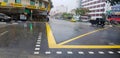 Road crossing with heavy rain and yellow line on street with building and car background.