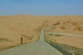 Road crossing sand dunes on the way to Qasr Al Sarab desert resort by Anantara in Abu Dhabi