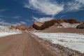 Road crossing Valle de la Luna. Dunes and rock formations covered with salt Royalty Free Stock Photo