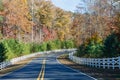 Road Curving Through Autumn Trees and White Fence Royalty Free Stock Photo