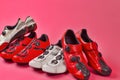 Road Cycling Concepts. Four Pairs of Carbon Red and White Professional Cycling Shoes Placed Together in Line Over Pink Coral