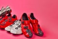 Road Cycling Concepts. Four Pairs of Carbon Red and White Professional Cycling Shoes Placed Together in Line Over Pink Coral