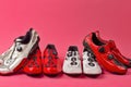 Road Cycling Ideas. Four Different Pairs of Carbon Red and White Professional Cycling Shoes Placed Together in Line Over Pink