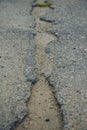 A road damaged by rain and snow, that is in need of maintenance. Broken asphalt pavement resulting in a pothole, dangerous to