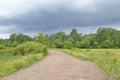 The road and the dark cloud. Royalty Free Stock Photo