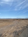 Buggy tracks. Road in the desert. Mountains on the horizon. Light clouds. Royalty Free Stock Photo