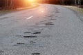 The road in disrepair with a lot of potholes. Cars go with the risk of breakdowns Royalty Free Stock Photo