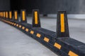 Road dividers with yellow stripes on road to underground garage