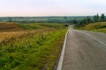 Road in the fields, the endless path of descents and ascents in the road, a long road in the journey Royalty Free Stock Photo