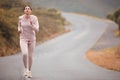 Road, fitness and woman running for exercise in nature for race, competition or marathon training. Challenge, sports and Royalty Free Stock Photo