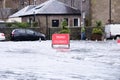 Road flood closed sign under deep water during bad extreme heavy rain storm weather in UK Royalty Free Stock Photo