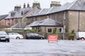 Road flood closed sign under deep water during bad extreme heavy rain storm weather in UK