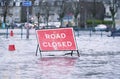 Road flood closed sign under deep water during bad extreme heavy rain storm weather in UK