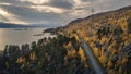 Road through forest along lake and mountains in Stora SjÃ¶fallet National Park in autumn in Lapland in Sweden from above Royalty Free Stock Photo