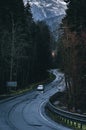 Road through the forest in autumn rainy day with a car Royalty Free Stock Photo