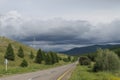 Road in forest under a blue sky with white clouds Sayan mountains Siberia Russia Royalty Free Stock Photo