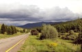 Road in forest under a blue sky with white clouds Sayan mountains Siberia Russia Royalty Free Stock Photo