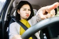 Asian woman driver angry at another car while driving on the road hand pointing at another driver Royalty Free Stock Photo