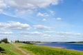 The road goes along the shore North of the river Vilyuy in the second half of the day near the houses of the village of Suntar.