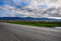 The road goes into the distance. Beautiful landscape. Blue sky with white clouds over the mountain valley. Royalty Free Stock Photo