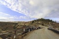 Road going over an area full of rocks towards the hill covered in trees Royalty Free Stock Photo