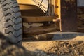 Road grader working at construction site for maintenance and construction of dirts and gravel road. Yellow motor grader. Heavy