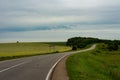 Road among grassed fields. Picturesque countryside Royalty Free Stock Photo