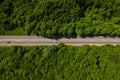 Road through the green forest, aerial view car drive going through forest, top down view forest, view from above Royalty Free Stock Photo