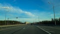 A road or highway leading to the horizon. View from the car window. Northern dim summer, blue sky with white clouds Royalty Free Stock Photo