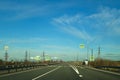 A road or highway leading to the horizon. View from the car window. Northern dim summer, blue sky with white clouds. Royalty Free Stock Photo