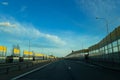 A road or highway leading to the horizon. View from the car window. Northern dim summer, blue sky with white clouds. Royalty Free Stock Photo