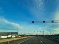 A road or highway leading to the horizon. View from the car window. Northern dim summer, blue sky with white clouds Royalty Free Stock Photo