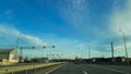 A road or highway leading to the horizon. View from the car window. Northern dim summer, blue sky with white clouds Royalty Free Stock Photo