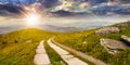 Road on a hillside near mountain peak at sunset Royalty Free Stock Photo