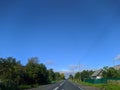 road with horizon on blue sky and white clouds view from the car. Royalty Free Stock Photo