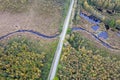 road intersecting blue river among autumn yellow forests, bogs Royalty Free Stock Photo