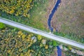 road intersecting blue river among autumn yellow forests, bogs Royalty Free Stock Photo