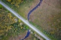 road intersecting blue river among autumn yellow forests, bogs Royalty Free Stock Photo